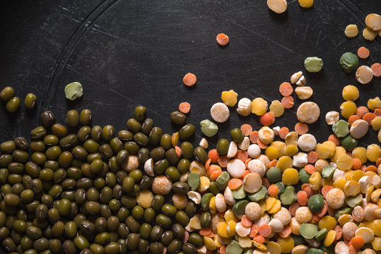 Placer lentils and green beans on a black table