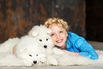 Little girl with a samoyed puppy