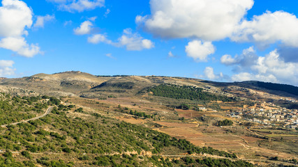 Fototapeta na wymiar Upper Galilee mountains landscape, Golan Heights nature view from Nimrod, beautiful sunny day, blue sky with white clouds, druze village, Israel. Concept: discover travel destination