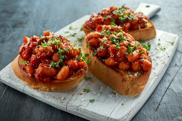 Beans fried in tomato sauce on toasted bread with cross salad sprinkle