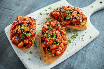 Beans fried in tomato sauce on toasted bread with cross salad sprinkle
