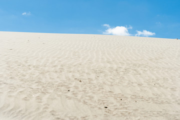 Stunning Mangawhai Heads sand dunes rising to blue sky 