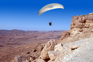 Paraglider taking off from a rock
