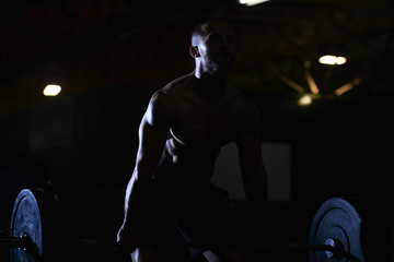 Fototapeta na wymiar Silhouette Man Standing Strong In The Gym And Flexing Muscles - Muscular Athletic Bodybuilder Fitness Model Posing After Exercises