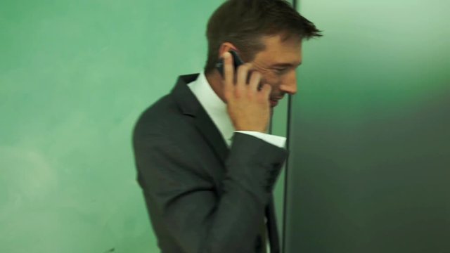 Businessman bursting out laughing during phone call