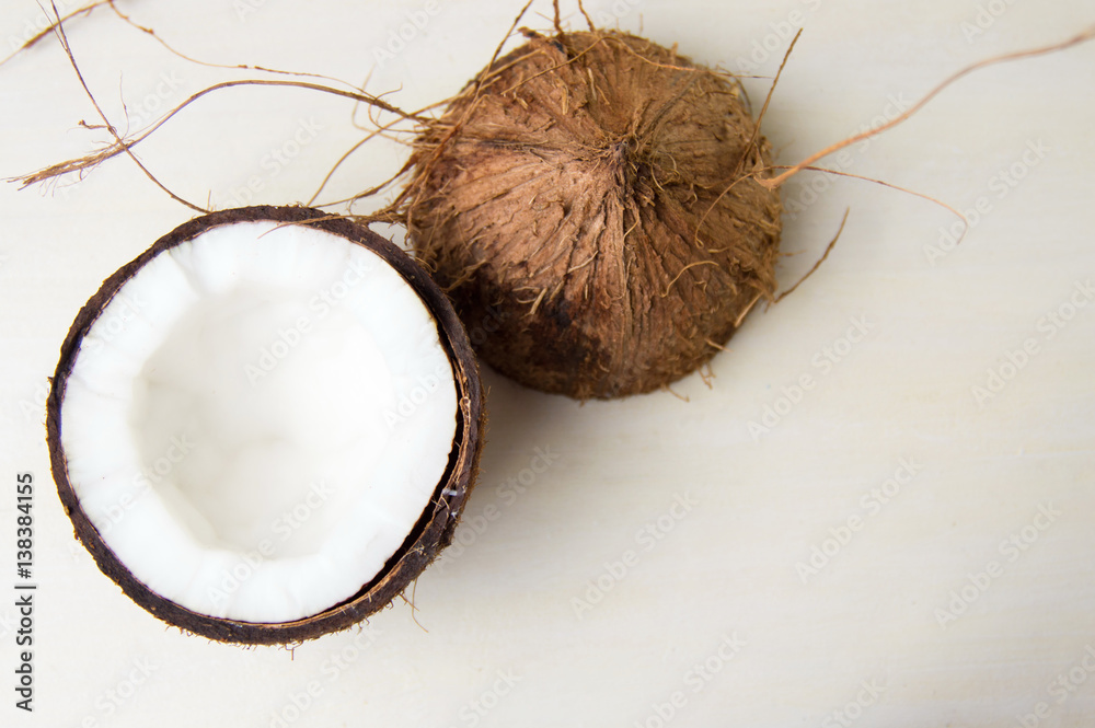 Wall mural Halved coconut on a wooden table