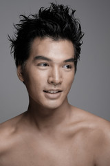 Fototapeta na wymiar Portrait of Asian man with beauty honey skin tone in gray background - Headshot