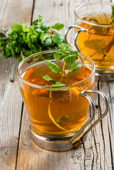 Homemade tea from mint leaves on a rustic wooden table, copy space
