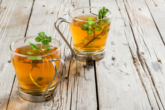 Homemade tea from mint leaves on a rustic wooden table, copy space