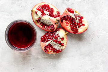 Obraz na płótnie Canvas glass of pomegranate juice with fresh slices on stone background top view