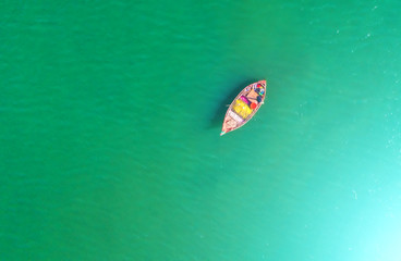 Fishing boat floating in the sea. The beautiful bright blue water in a clear day.Aerial view.Top view.