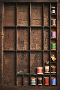 vintage spools of thread on old wooden drawer