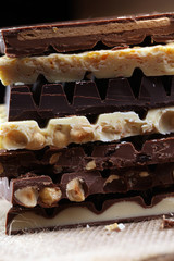 Chocolate bars on a wooden background with chocolate tower