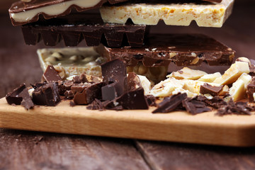 Chocolate bars on a wooden background with chocolate tower