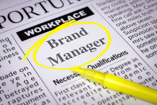 Brand Manager - Newspaper sheet with ads and job search, circled with yellow marker, Blurred image and selective focus