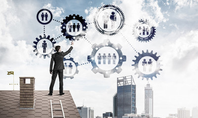 Businessman on house roof presenting teamwork and connection con