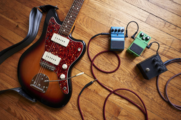 an electric guitar with cables and pedals