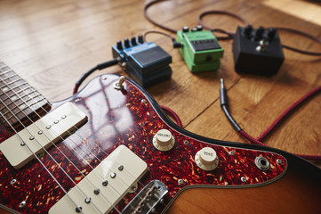 an electric guitar with cables and pedals
