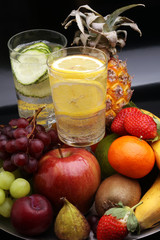 fitness equipment and healthy food and detox water (green apple, pepper, grapes, nectarines, kiwi, orange, dumbbells and measuring tape)