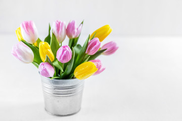Bouquet of fresh tulips in a metal pot.