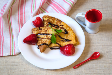 Fototapeta na wymiar Beautiful baked pancakes with red berries on a white plate