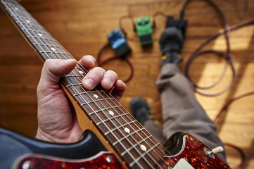 a person playing a guitar and using effect pedals