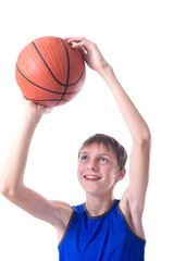 Teenager in blue shirt laughing and throwing a ball for basketball. Isolated on white background