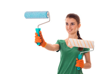 studio portrait of young happy brunette girl in uniform makes renavation with paint roller in hands smiling isolated on white background