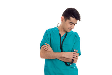 portrait of pretty brunette male doctor in blue uniform with stethoscope posing isolated on white background