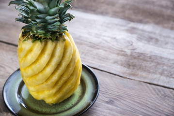 Pineapple on the plate on the wooden background