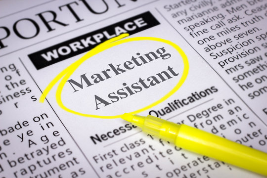 Marketing Assistant - Newspaper sheet with ads and job search, circled with yellow marker, Blurred image and selective focus