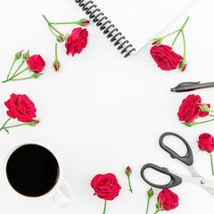 Round workspace on white background with notebook, red roses and office supplies. Scissors, pen and coffee mug. Flat lay, top view