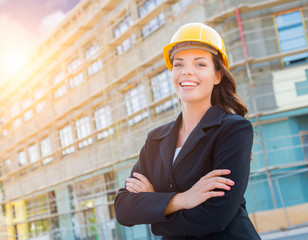 Portrait of Young Attractive Professional Female Contractor Wearing Hard Hat at Construction Site.