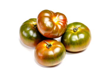 Green, black tomato are on the Board. Isolated.