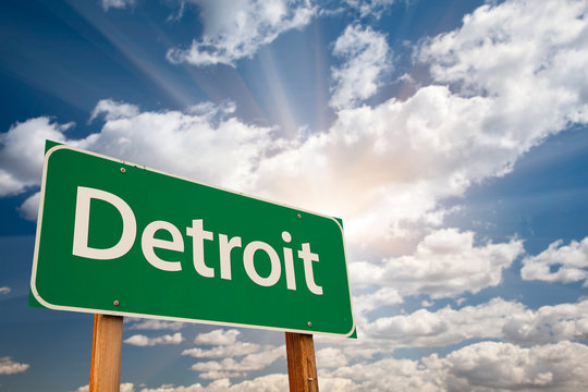 Detroit Green Road Sign Over Dramatic Clouds and Sky.