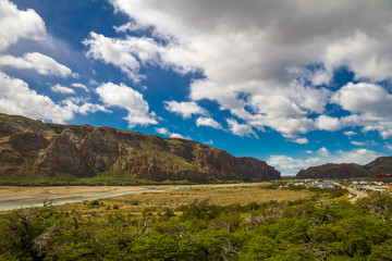 Amazing landscape of the mountains, river and forest. Blue sky with clouds.