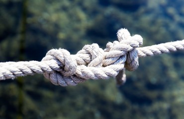 White rope with a knot on blue sea background