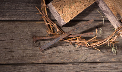 Crown of Thorns and Nails on a Weathered Wooden Background