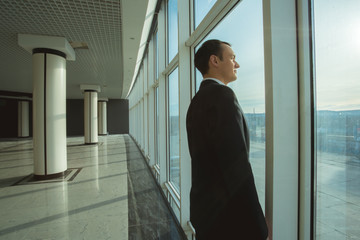 The businessman stand near panoramic window