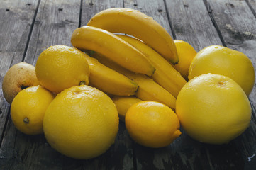 Bunch of fresh yellow fruit on an old wooden table. Selective focus and small depth of field.