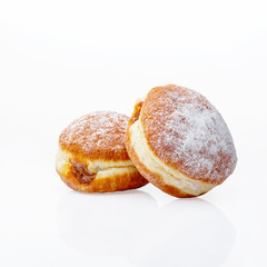 Two donuts with chocolate filling on a white background. Isolated items. Golden pastries dusted with powdered sugar. Studio.