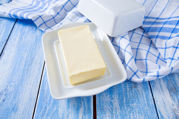 butter on butter dish on blue wooden surface