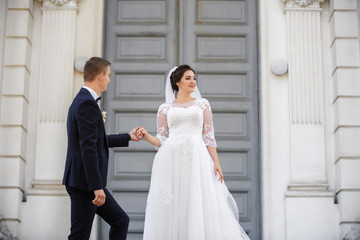 Bride and groom holding hands and walking after wedding ceremony in church