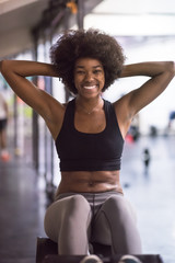 Fototapeta na wymiar black woman doing sit ups at the gym