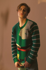Cute guy in hipster clothes 90s posing in studio