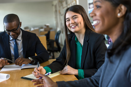 Asian American Business Woman With Diverse Group At An Executive Meeting In Discussion