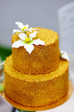 Gold Wedding Cake Decorated With White Sugar Flowers