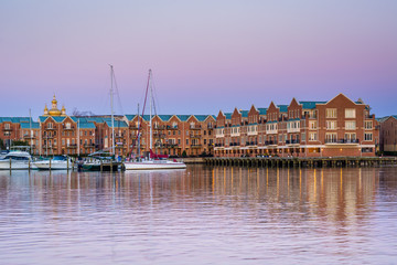 Buildings and boats docked on the Canton Waterfront at twilight, in Baltimore, Maryland.