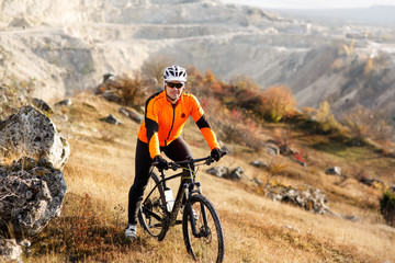 Cyclist Riding the Bike Down Rocky Hill. Extreme Sport Concept. Space for Text.