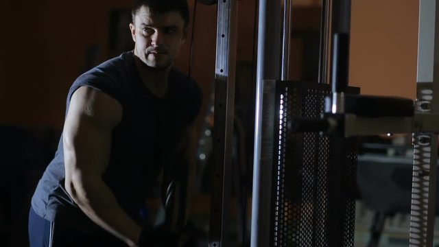 extension arms in the simulator, training triceps. bodybuilder training . gym.